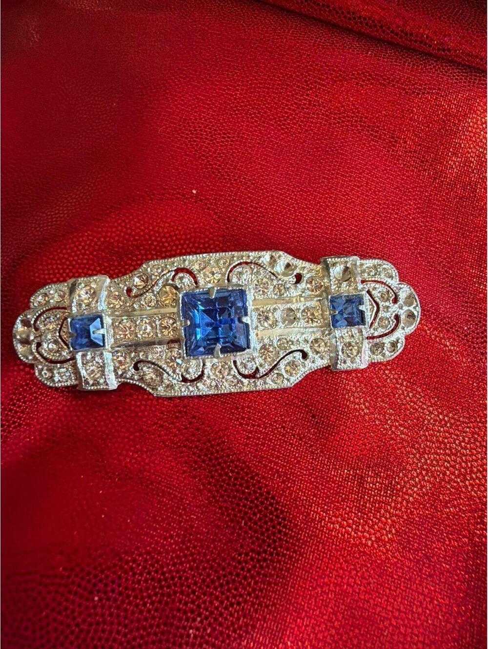 Brooch Art Deco style brooch featuring blue stones and clear stones set in a